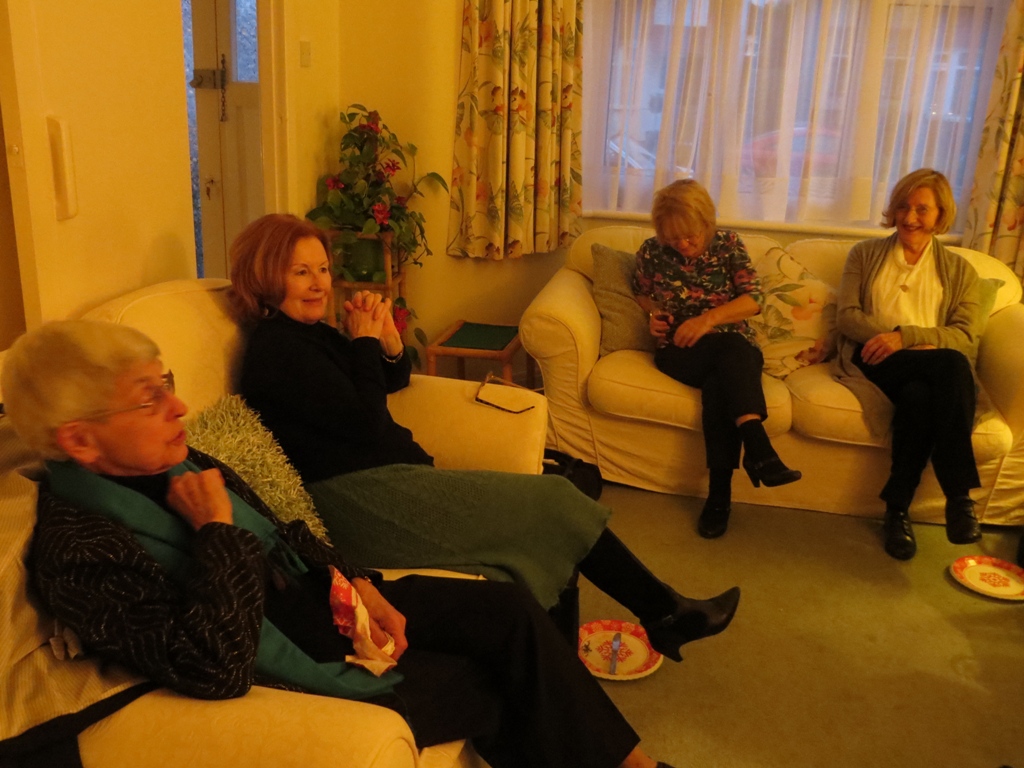 Four women seated on two sofas in a room
