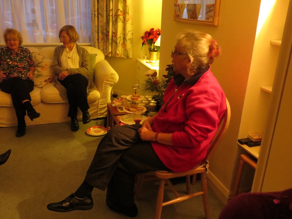Three seated women and a table of food