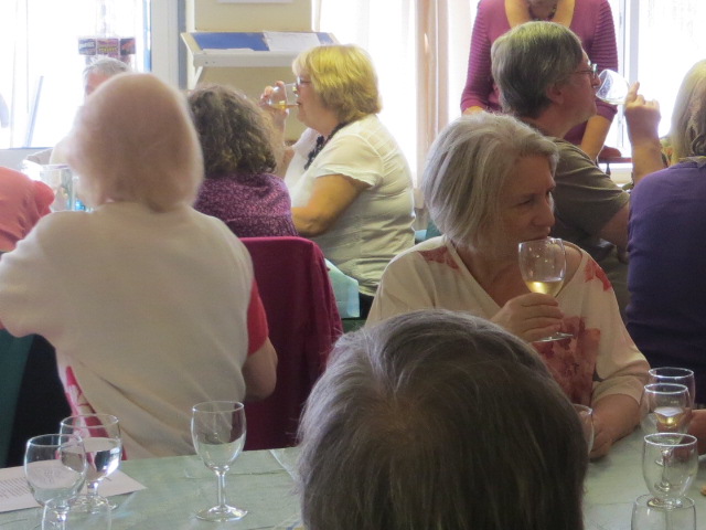 People, seated at tables, having a drink