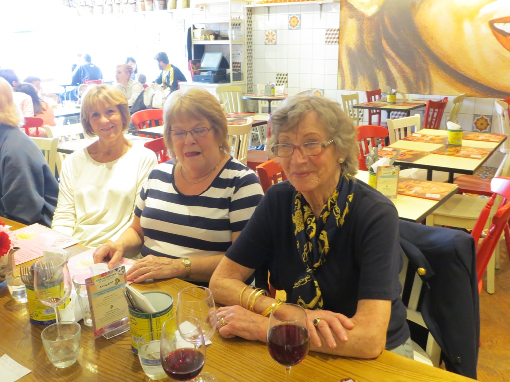 People seated at a table about to order a meal in a restaurant, posing for a photo