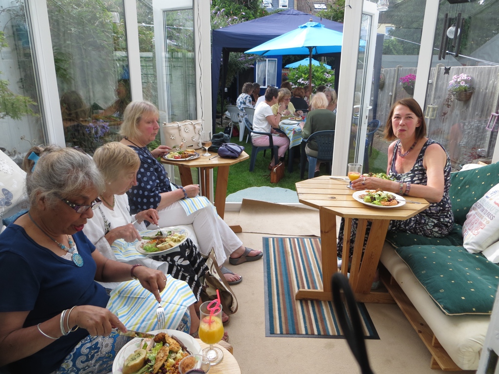 People seated indoors and outdoors having a meal