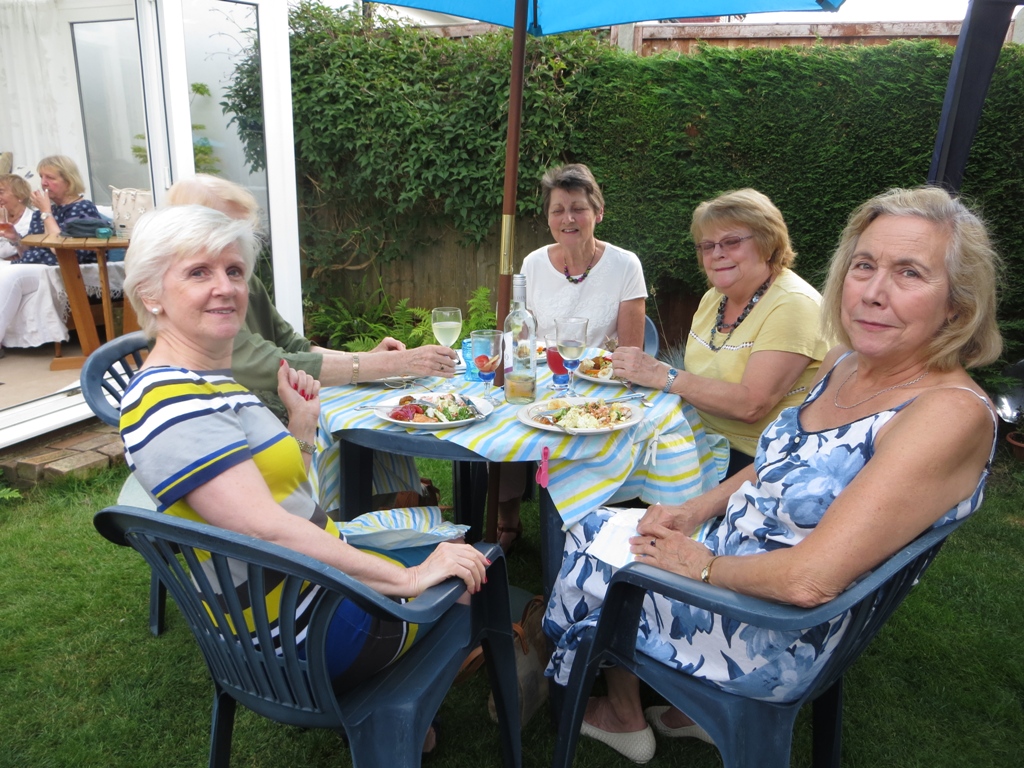 People seated around a table having a meal, posing for a photo